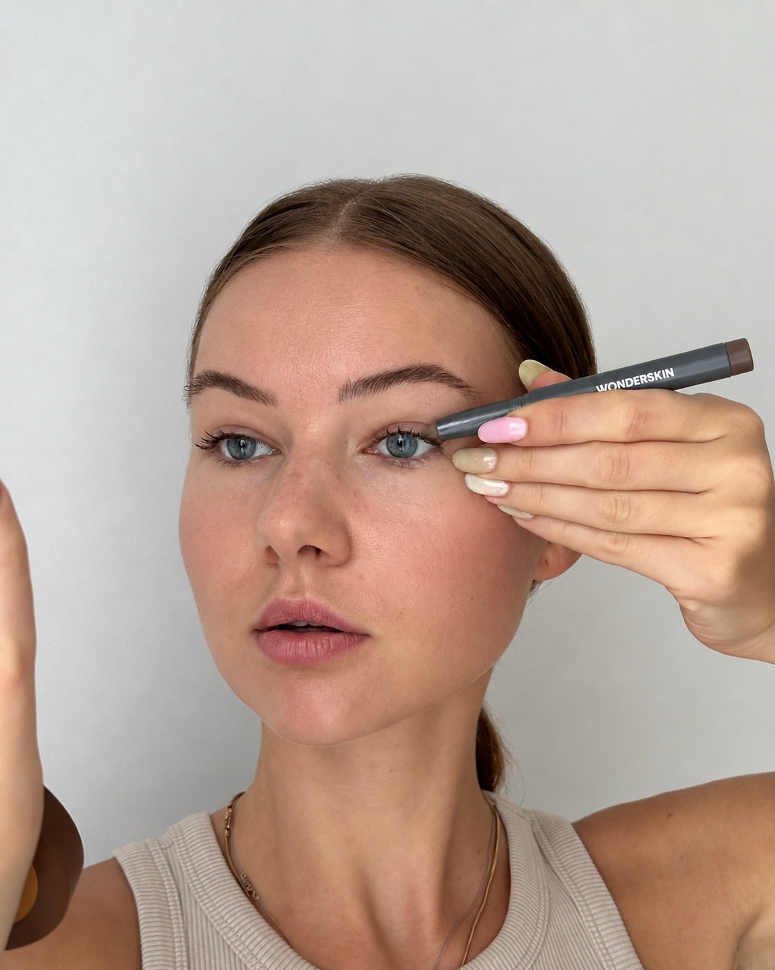 Klaudija applying brown Wonderskin eyeshadow by a mirror